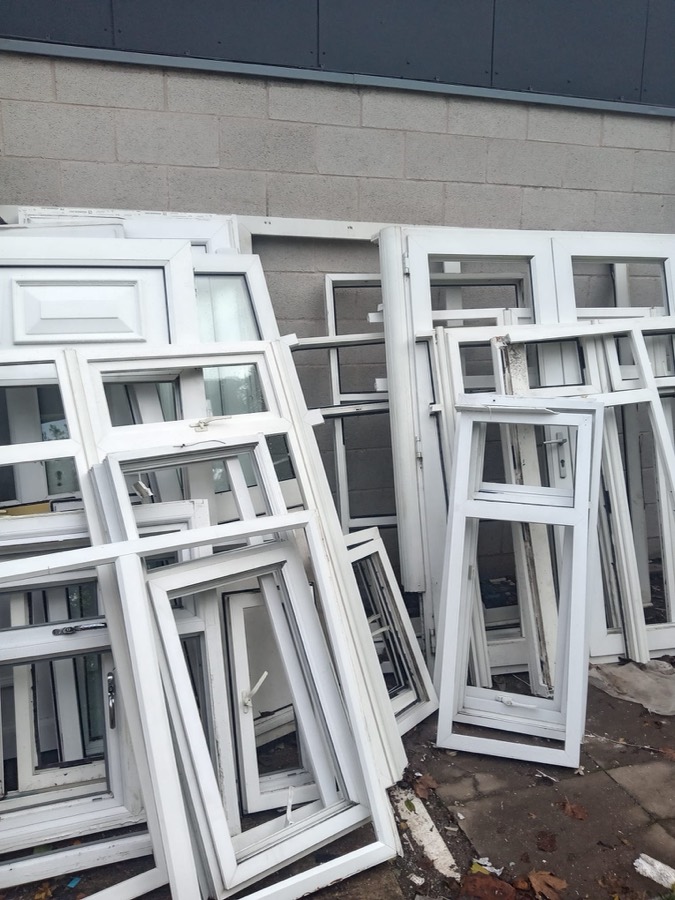 Pile of scrap white uPVC window frames ready for collection
