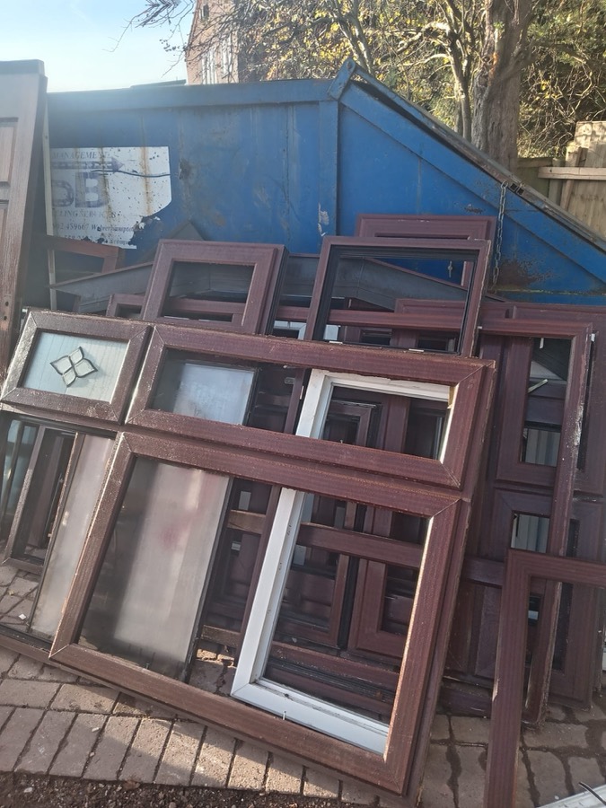 Coloured rosewood uPVC frames stacked for collection