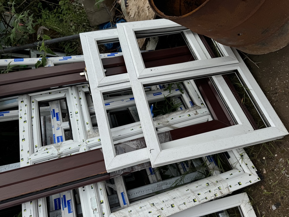 Mixed scrap uPVC window frames stacked at our collection yard
